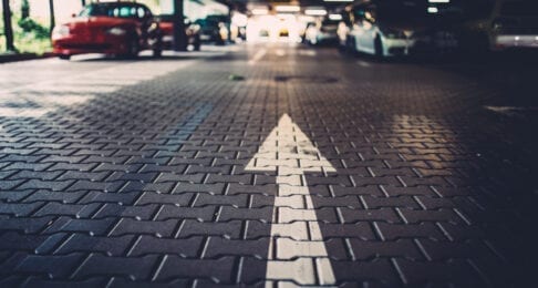 Foto von Pfeil auf der Straße, der in Parkhaus zeigt; symbolisiert verbessertes Kundenerlebnis
