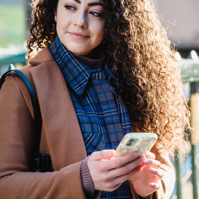 Foto einer Frau, die über Ihr Handy Ihre Parkplatzgebühr bezahlt